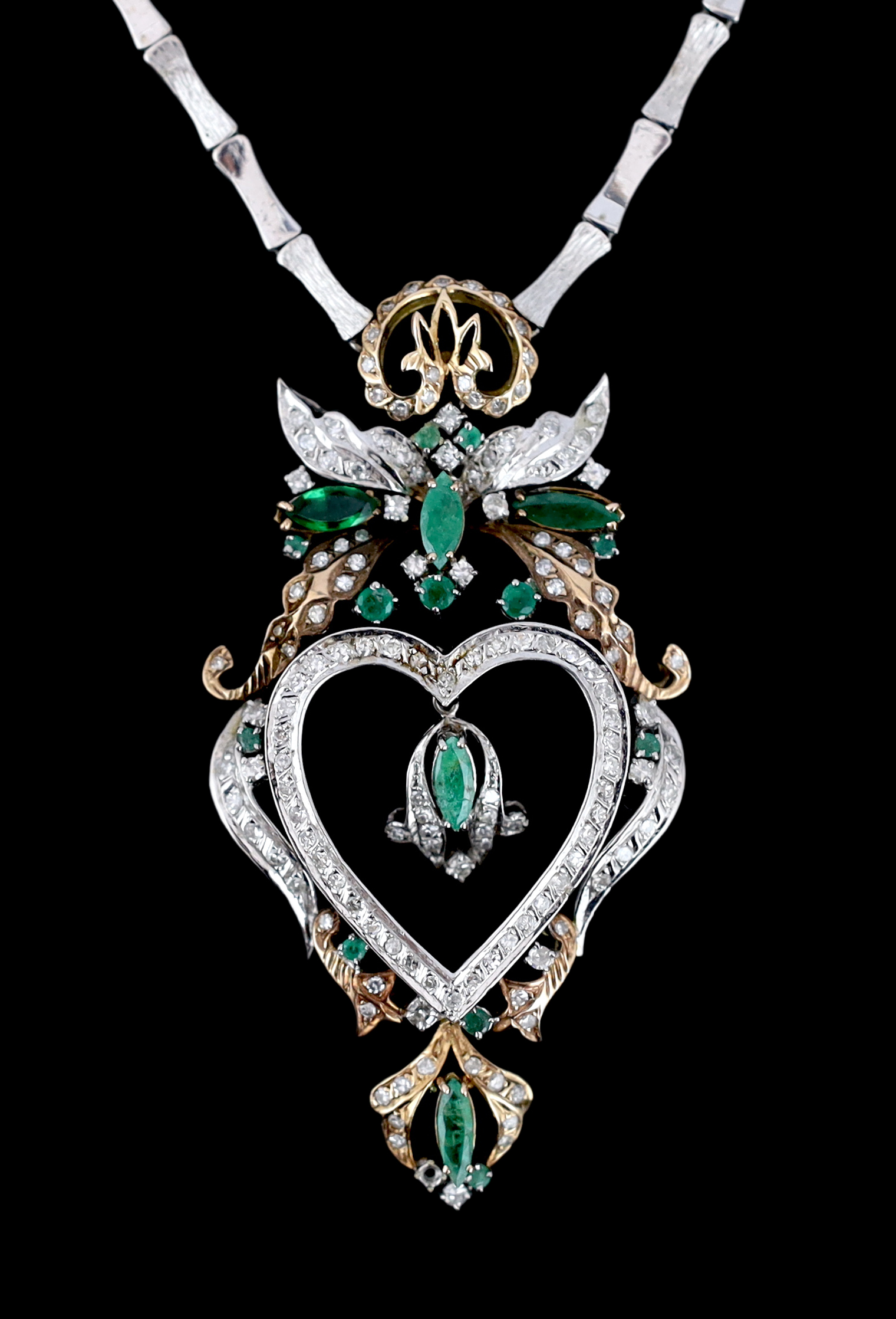 A late 20th century Middle Eastern two colour gold, emerald and diamond cluster heart shaped pendant necklace